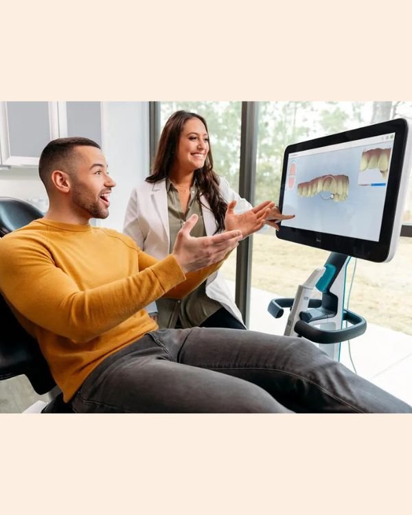 Dr Nikhil Sharma showing a 3D digital dental scan to a patient during orthodontic consultation in Dubai