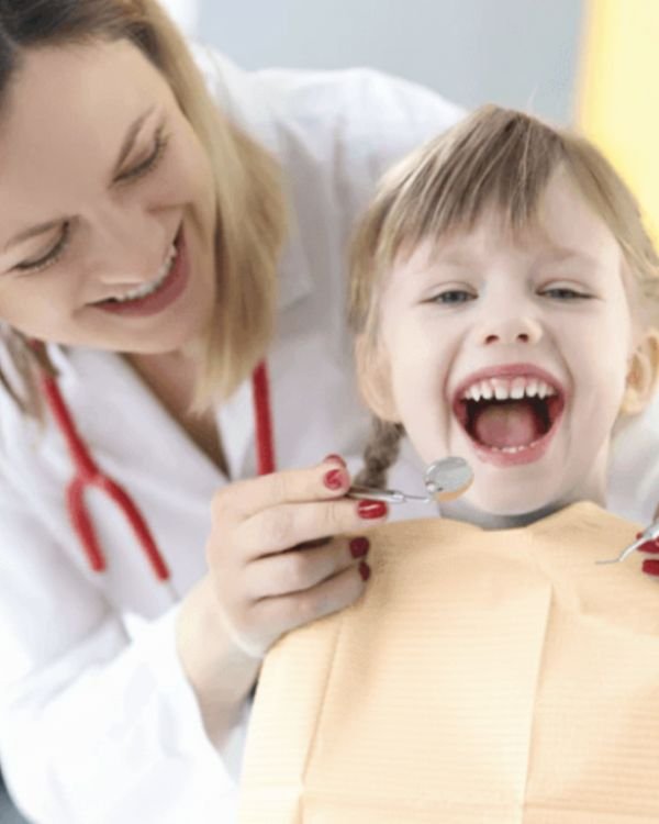 A young child smiling during a gentle orthodontic check-up at Invisible Braces Dental & Skin Clinic, Dubai, under the care of Dr. Nikhil Sharma’s team.