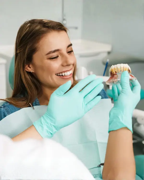 Patient reviewing dental prosthesis model with prosthodontist during smile restoration consultation at Invisible Braces Dental Clinic