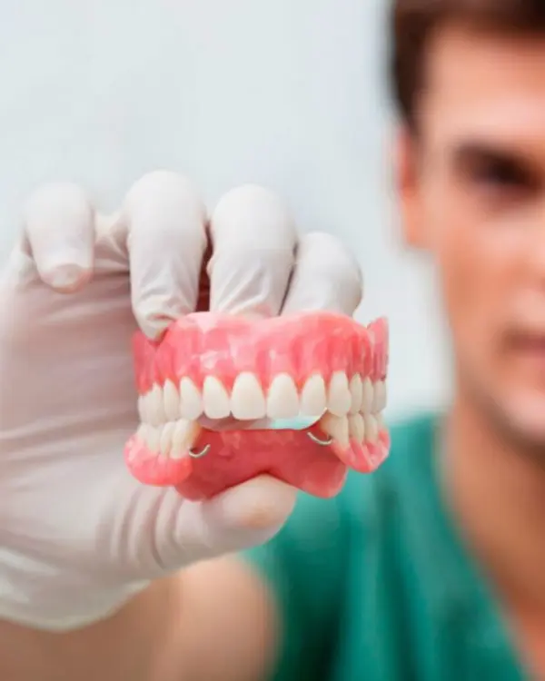 Dental professional holding high-quality lightweight dentures made from durable materials