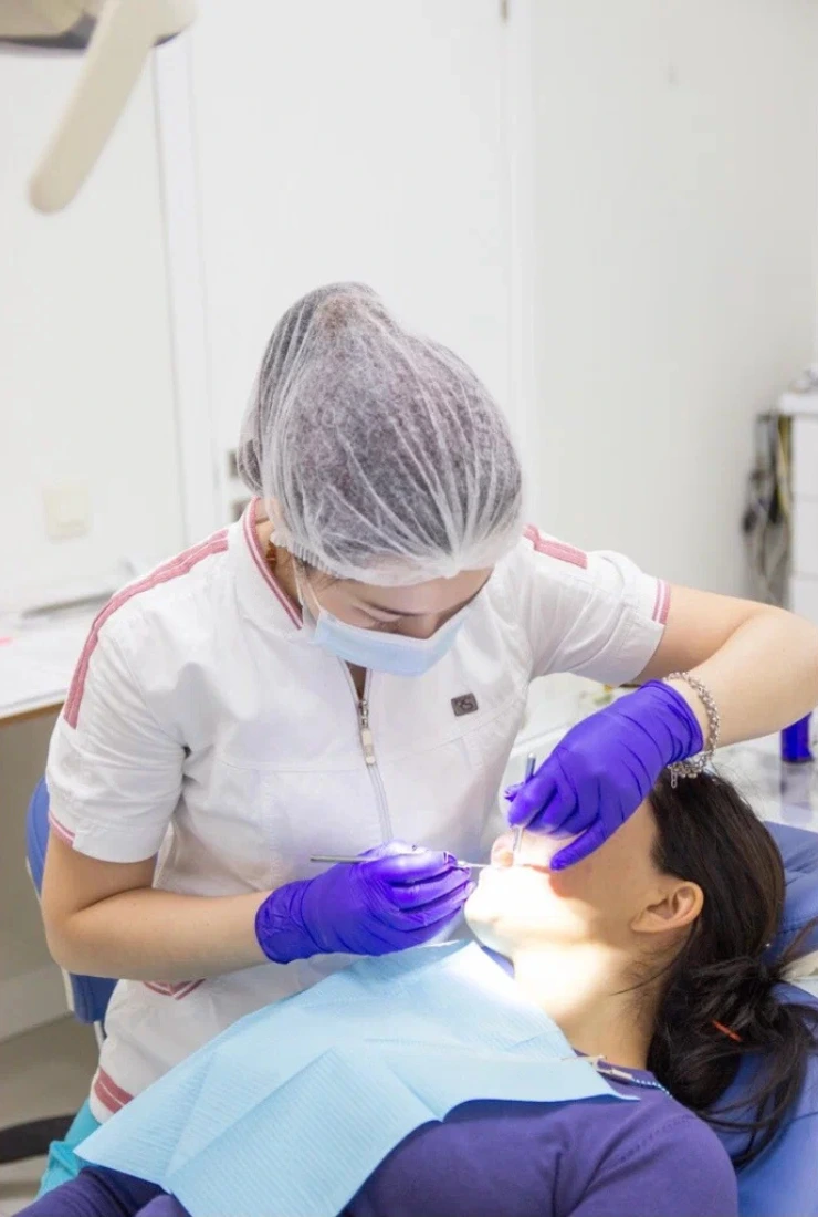 Dentist performing a sterile tooth extraction procedure at Invisible Braces Dental & Skin Clinic.
