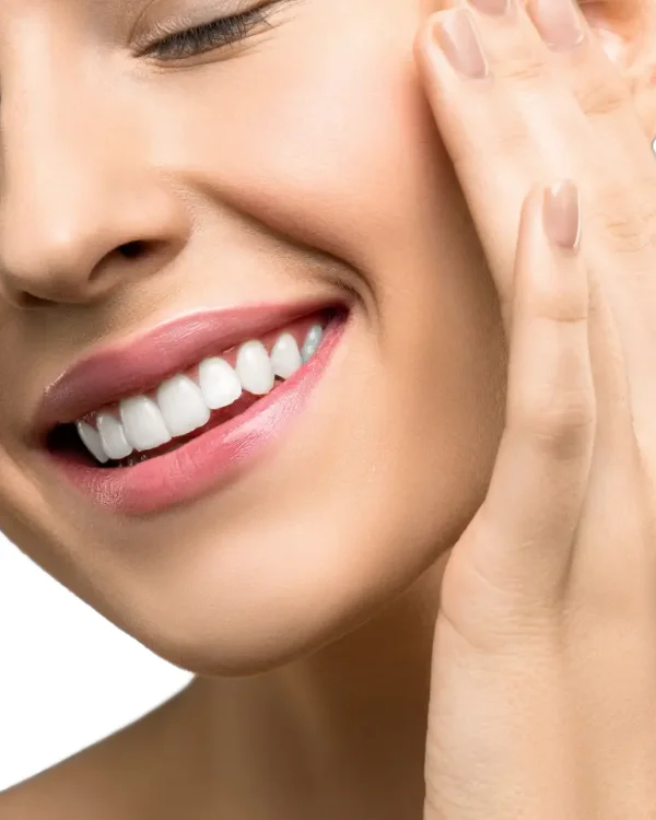 Woman smiling with straight teeth after Damon braces orthodontic treatment.